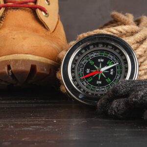 Compass surrounded by mountain gear tools on woode 2023 11 27 05 11 16 utc